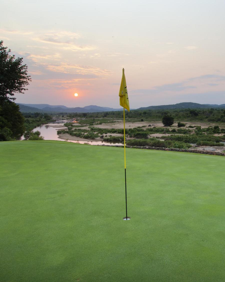 Golf green at sunset, looking out into the Kruger's wild bush